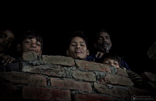 Indian family look over house wall